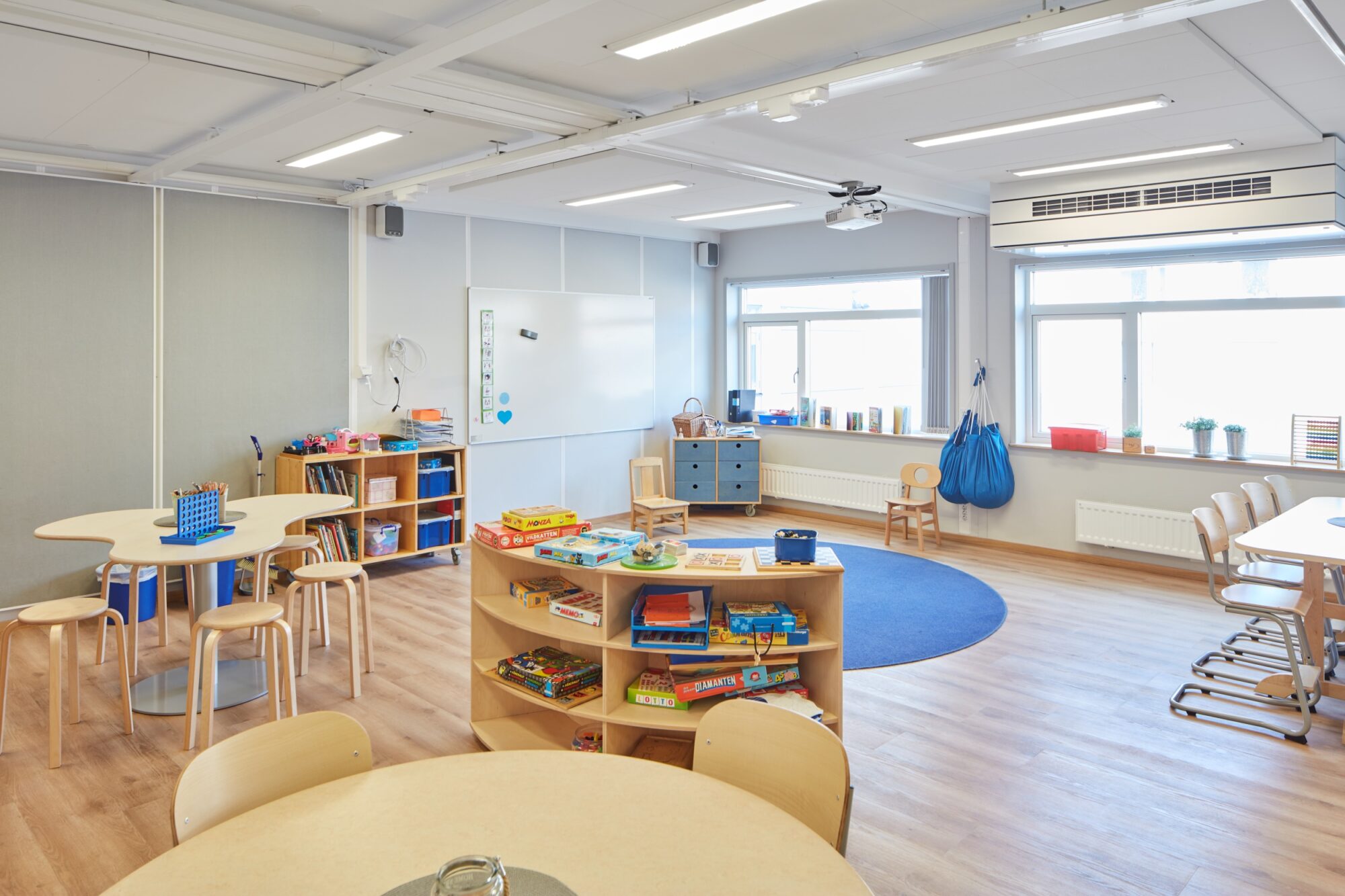 Insidan av en förskolemodul med stora fönster och öppen planlösning.